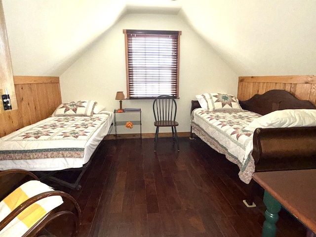 bedroom with baseboards, wood finished floors, and lofted ceiling