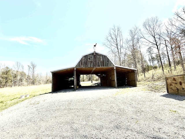 view of barn with a carport and driveway