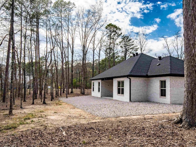 rear view of property featuring a shingled roof