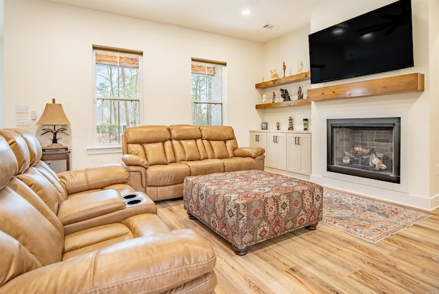 living room with visible vents, light wood-type flooring, recessed lighting, and a fireplace