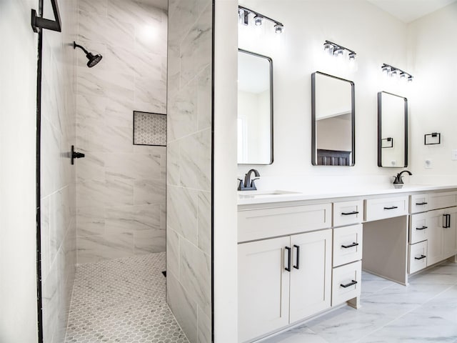 bathroom with a sink, double vanity, marble finish floor, and tiled shower