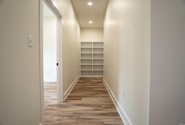 hall with visible vents, baseboards, recessed lighting, and wood finished floors