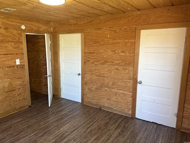 604 E Church St, Morrilton, AR 72110 - unfurnished bedroom with dark wood-type flooring, visible vents, wooden walls, and wood ceiling