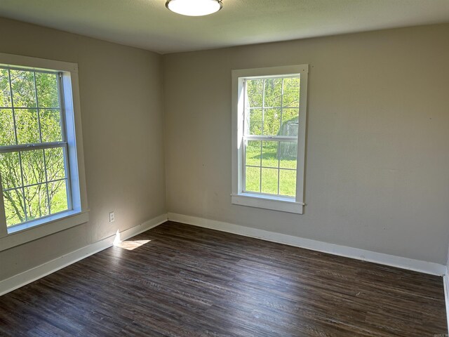 604 E Church St, Morrilton, AR 72110 - spare room with a healthy amount of sunlight, baseboards, and dark wood finished floors