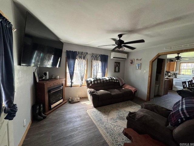 95 Terrafirma Ln, Ash Flat, AR 72513 - living area with ceiling fan, a wall unit AC, a glass covered fireplace, wood finished floors, and baseboards