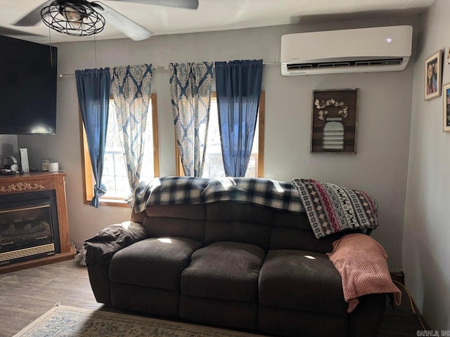 95 Terrafirma Ln, Ash Flat, AR 72513 - living area with wood finished floors, ceiling fan, an AC wall unit, and a glass covered fireplace