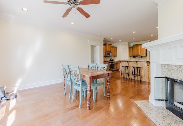 3015 Woodsgate, Little Rock, AR 72211 - dining space featuring light wood-style floors, ceiling fan, a fireplace, and ornamental molding