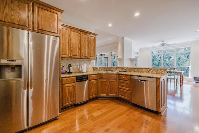 3015 Woodsgate, Little Rock, AR 72211 - kitchen featuring brown cabinetry, appliances with stainless steel finishes, a sink, and light stone countertops