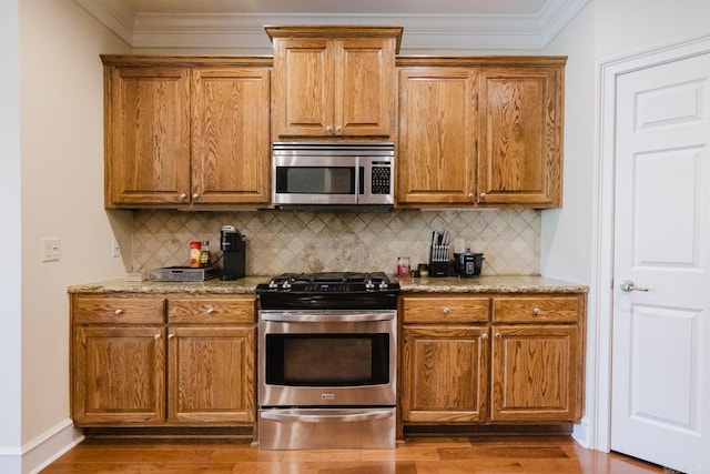 3015 Woodsgate, Little Rock, AR 72211 - kitchen with crown molding, appliances with stainless steel finishes, wood finished floors, and light stone countertops