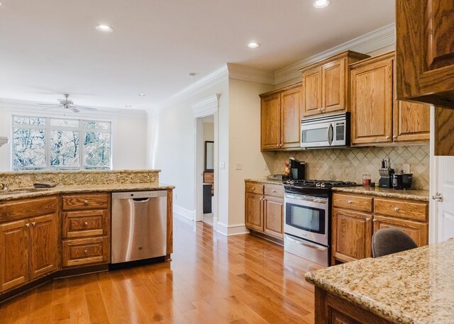 3015 Woodsgate, Little Rock, AR 72211 - kitchen featuring crown molding, backsplash, appliances with stainless steel finishes, and light stone counters