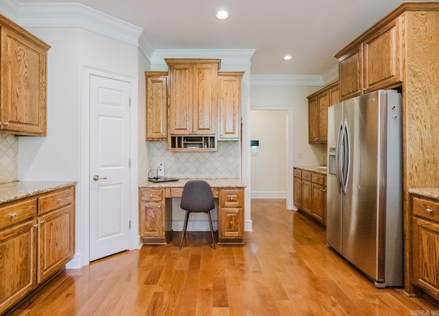 3015 Woodsgate, Little Rock, AR 72211 - kitchen with stainless steel fridge, light wood-type flooring, crown molding, brown cabinetry, and built in study area
