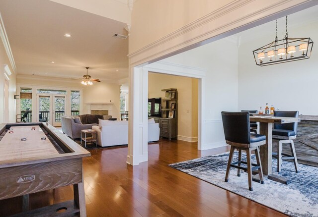 3015 Woodsgate, Little Rock, AR 72211 - dining area featuring visible vents, a tiled fireplace, ornamental molding, ceiling fan, and wood finished floors