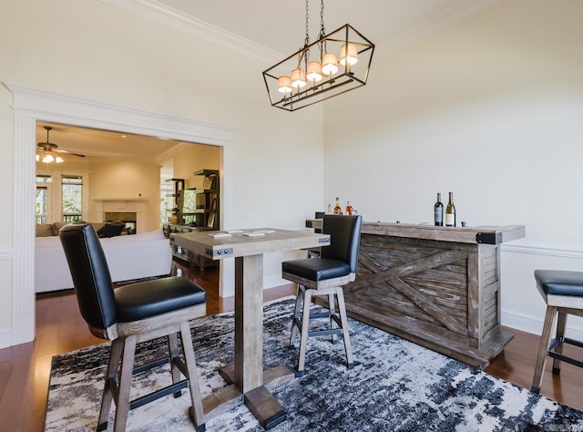 3015 Woodsgate, Little Rock, AR 72211 - dining room with crown molding, wood finished floors, a fireplace, and a dry bar