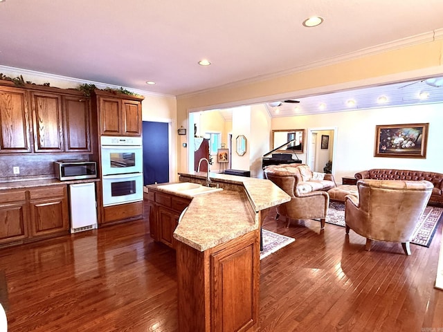 2832 Lacrosse Rd, Melbourne, AR 72556 - kitchen featuring white double oven, light stone counters, a sink, open floor plan, and dark wood-style floors