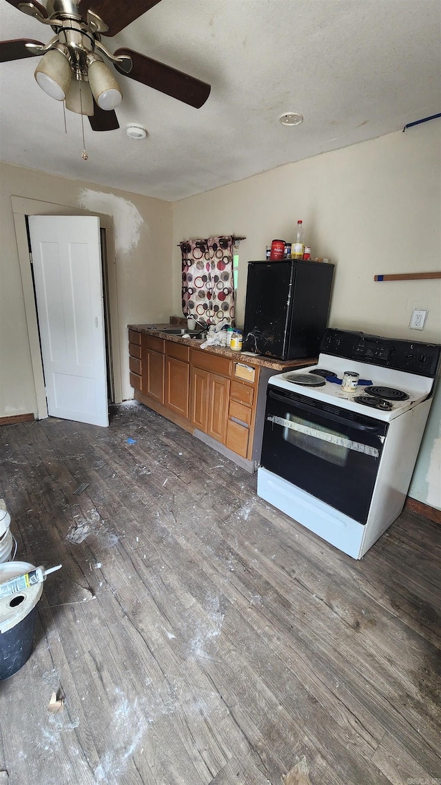 417B Mississippi St, Hot Springs, AR 71901 - kitchen with electric range, wood finished floors, a ceiling fan, and brown cabinetry