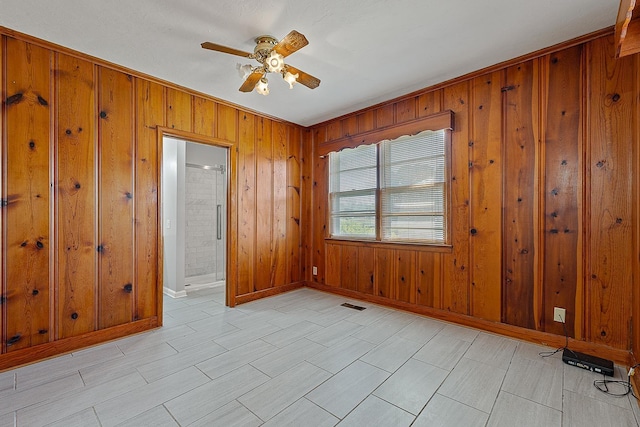 2812 N Church, Jonesboro, AR 72401 - spare room featuring wood walls, visible vents, baseboards, and ceiling fan