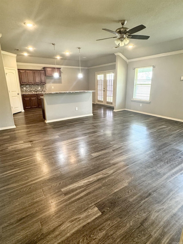 unfurnished living room with crown molding, ceiling fan, dark wood-type flooring, french doors, and baseboards