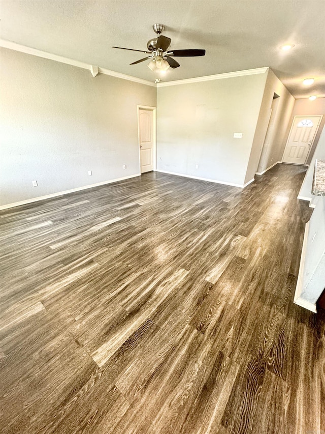 unfurnished living room featuring ceiling fan, dark wood finished floors, a textured ceiling, ornamental molding, and baseboards