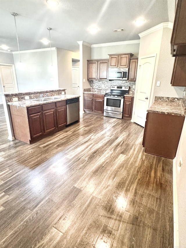 kitchen featuring ornamental molding, visible vents, stainless steel appliances, a sink, and wood finished floors