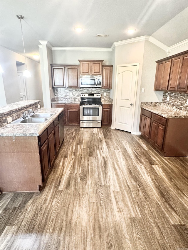 kitchen featuring tasteful backsplash, visible vents, appliances with stainless steel finishes, a sink, and wood finished floors