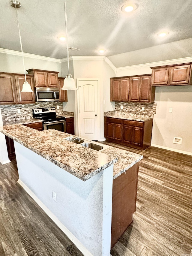 kitchen featuring tasteful backsplash, a textured ceiling, dark wood finished floors, stainless steel appliances, and a sink