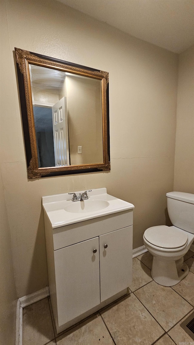 bathroom with baseboards, vanity, tile patterned floors, and toilet
