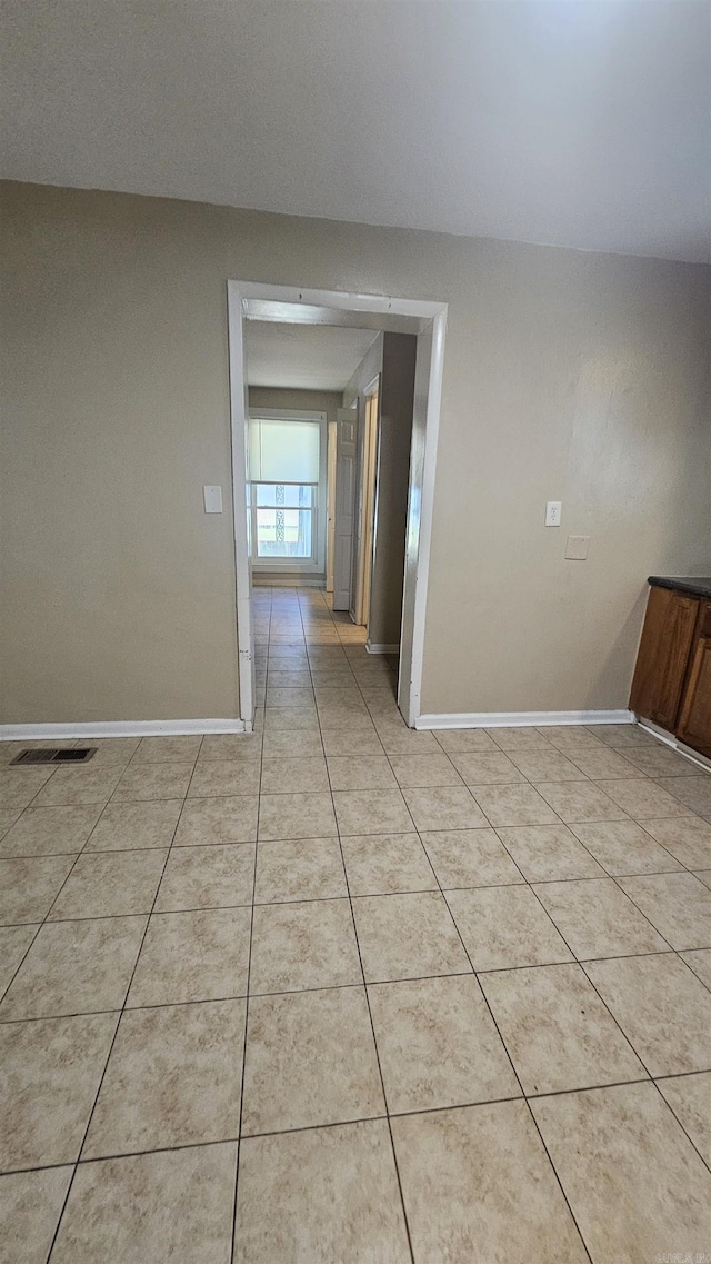 spare room featuring visible vents, baseboards, and light tile patterned floors