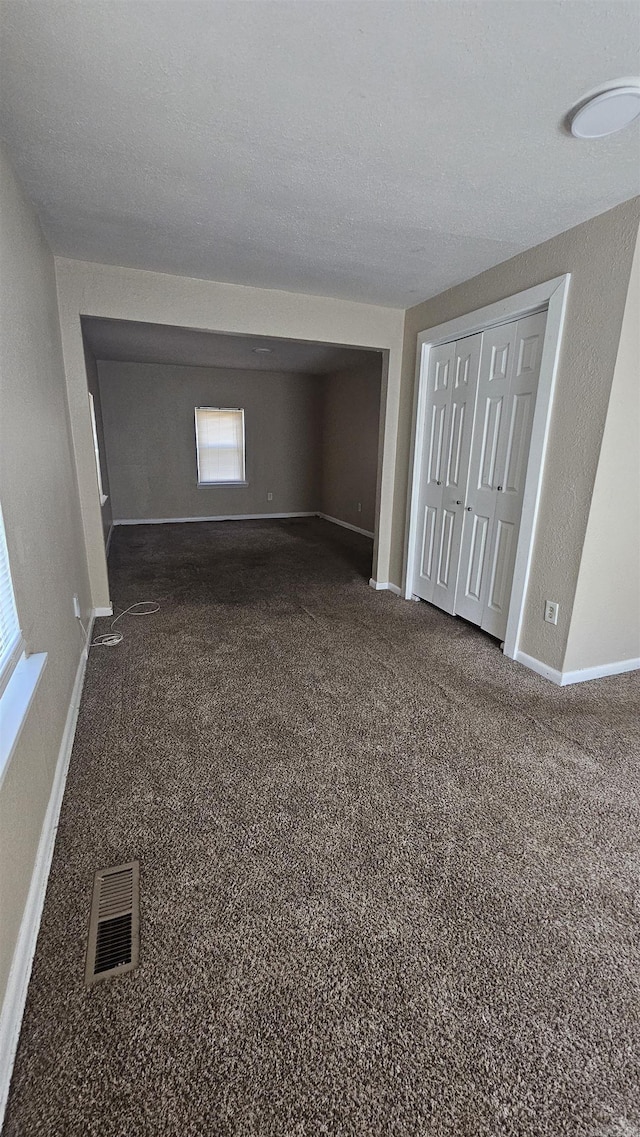 interior space featuring carpet floors, visible vents, and baseboards