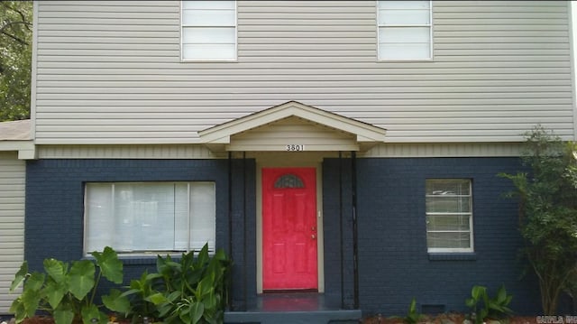 view of exterior entry featuring brick siding