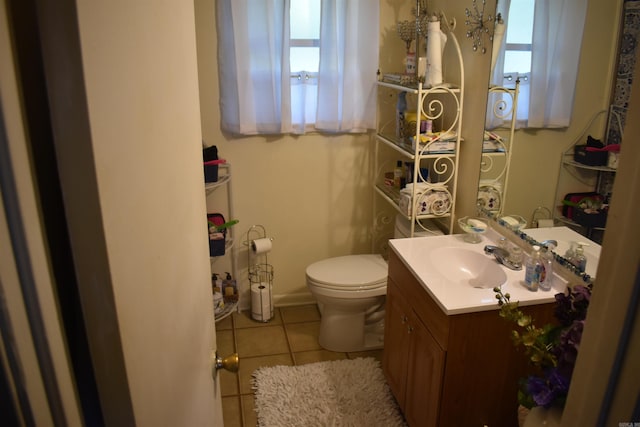 half bathroom with tile patterned floors, toilet, and vanity