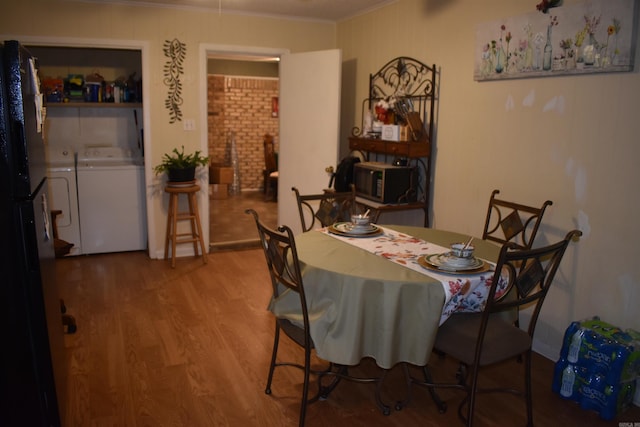 dining space featuring ornamental molding, wood finished floors, and independent washer and dryer