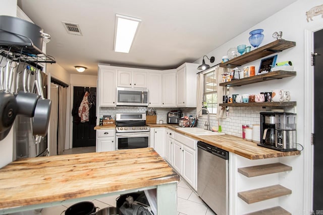 3712 Hazelwood Dr, Benton, AR 72015 - kitchen featuring butcher block counters, open shelves, a sink, stainless steel appliances, and backsplash