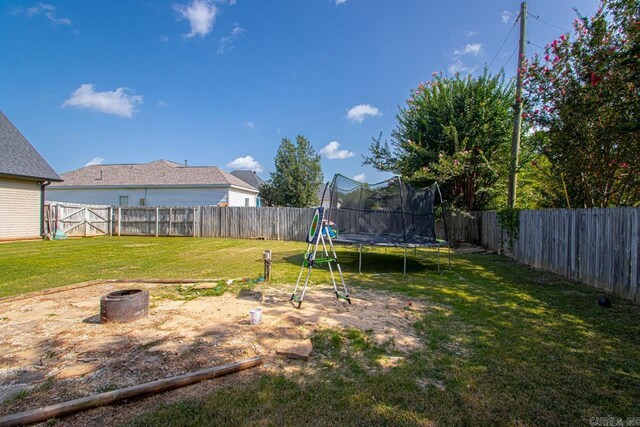 3712 Hazelwood Dr, Benton, AR 72015 - view of yard featuring a fenced backyard, an outdoor fire pit, and a trampoline