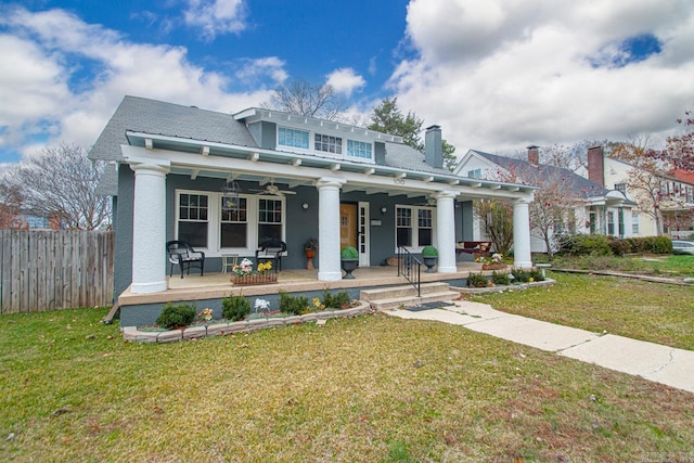view of front of house featuring a front lawn, fence, stucco siding, and a ceiling fan