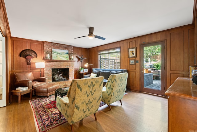 5 Huntington Rd, Little Rock, AR 72227 - living area with wood walls, light wood-style flooring, a brick fireplace, and ceiling fan