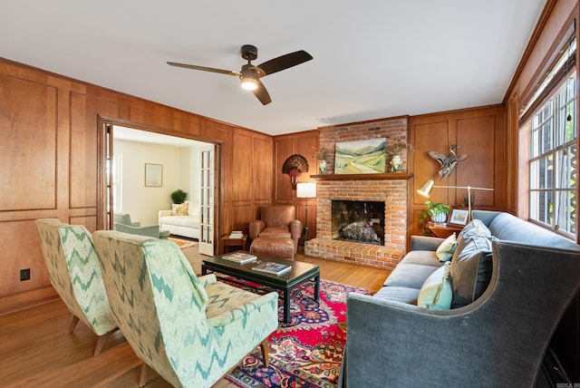 5 Huntington Rd, Little Rock, AR 72227 - living room with wooden walls, wood finished floors, a brick fireplace, and a ceiling fan