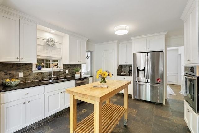5 Huntington Rd, Little Rock, AR 72227 - kitchen with dark countertops, a sink, stainless steel appliances, white cabinets, and backsplash