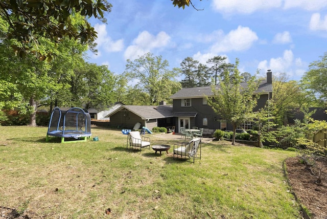 5 Huntington Rd, Little Rock, AR 72227 - view of yard with a trampoline, a patio area, and an outdoor living space with a fire pit