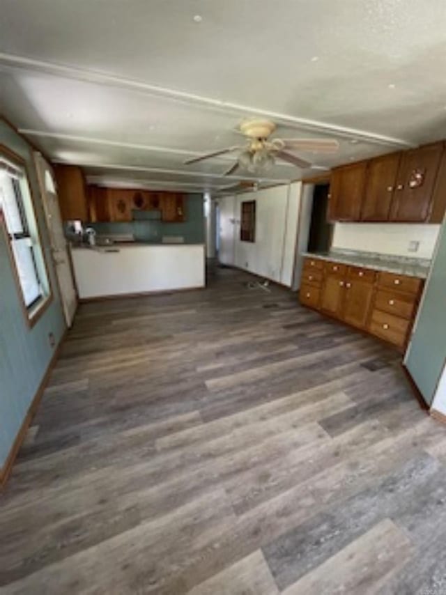 kitchen featuring brown cabinetry, baseboards, ceiling fan, and dark wood finished floors