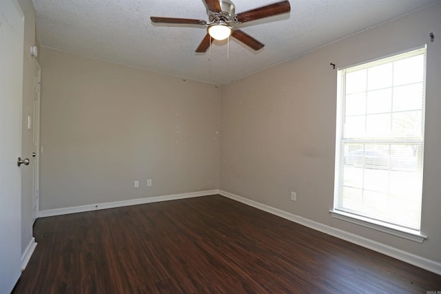 empty room with baseboards, a ceiling fan, plenty of natural light, and wood finished floors