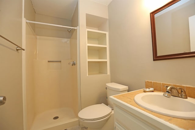 bathroom with toilet, a shower stall, and vanity