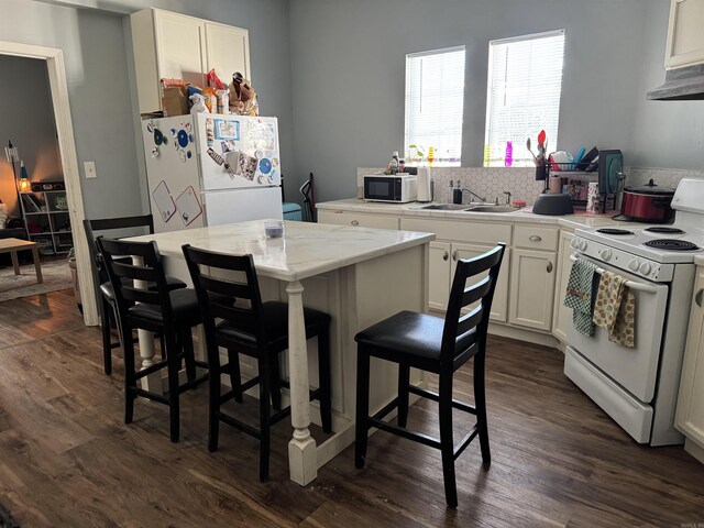 kitchen featuring white cabinetry, dark wood-style flooring, a sink, and white appliances