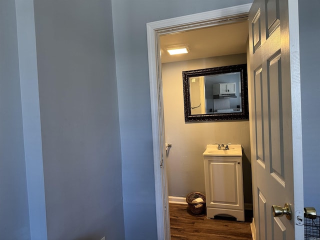 bathroom featuring baseboards, vanity, and wood finished floors