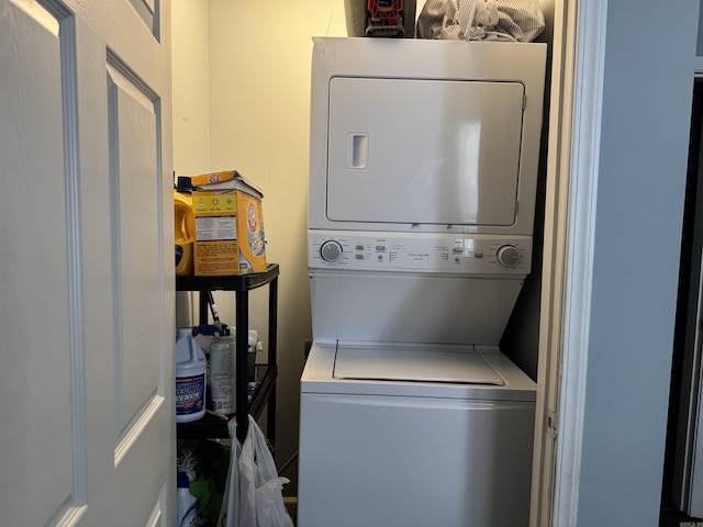 laundry room featuring stacked washer / drying machine and laundry area