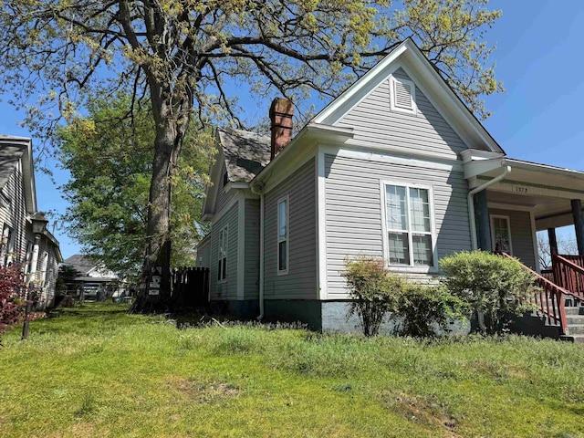 view of property exterior with a chimney and a yard