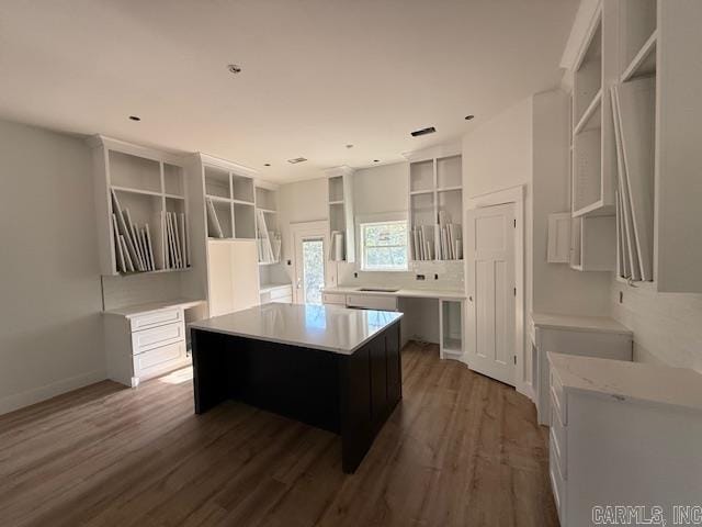 kitchen with a center island, open shelves, baseboards, recessed lighting, and wood finished floors