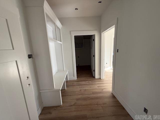 corridor featuring light wood-type flooring and baseboards