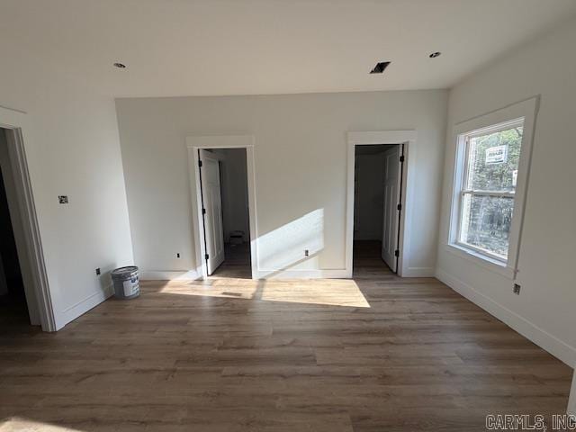 unfurnished bedroom featuring wood finished floors and baseboards