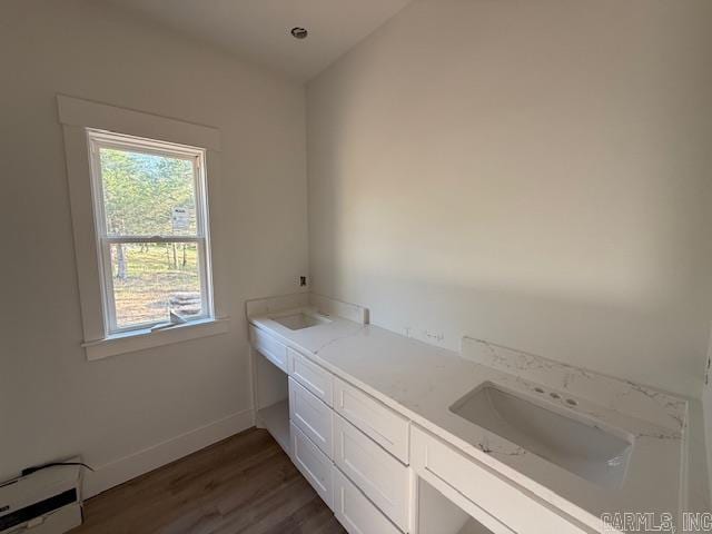 bathroom with plenty of natural light, baseboard heating, baseboards, and wood finished floors