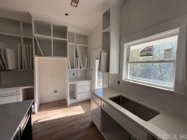 kitchen featuring tasteful backsplash, open shelves, wood finished floors, and vaulted ceiling